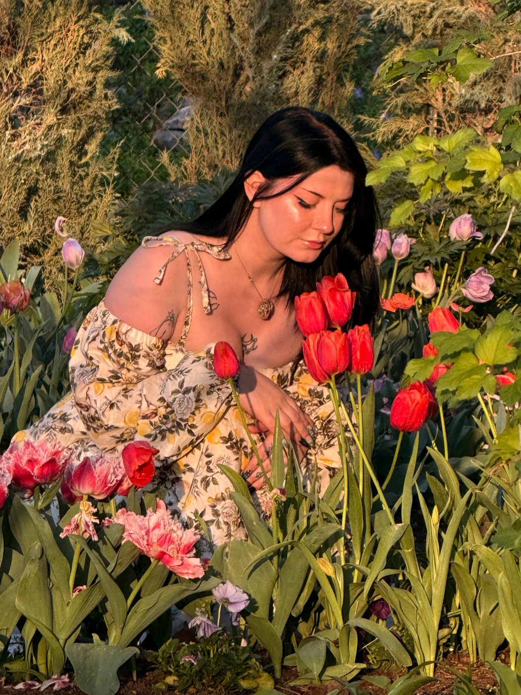 Brianna in a floral dress among tulips at sunset